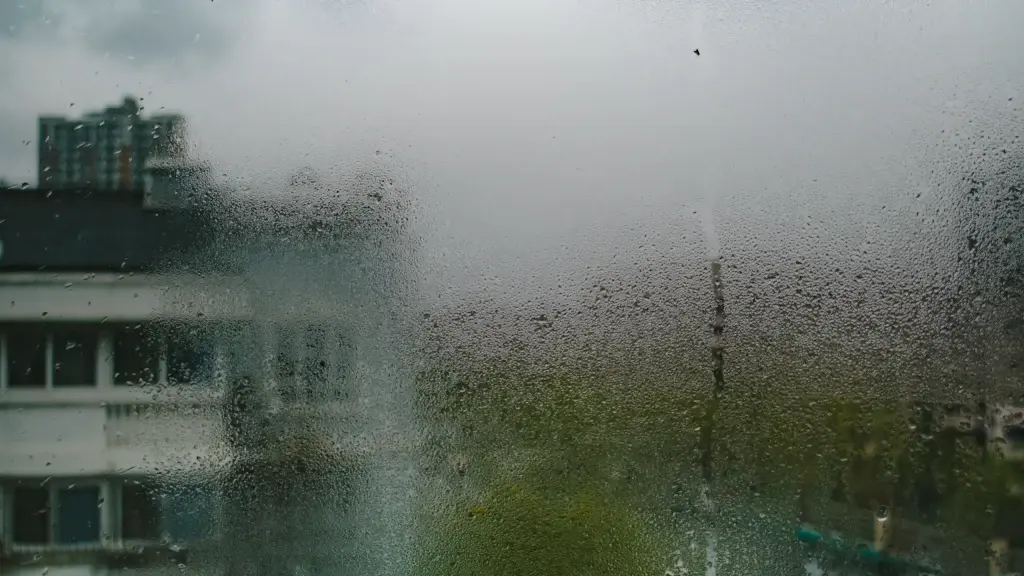 Vitre embuée par la condensation, immeuble flou derrière